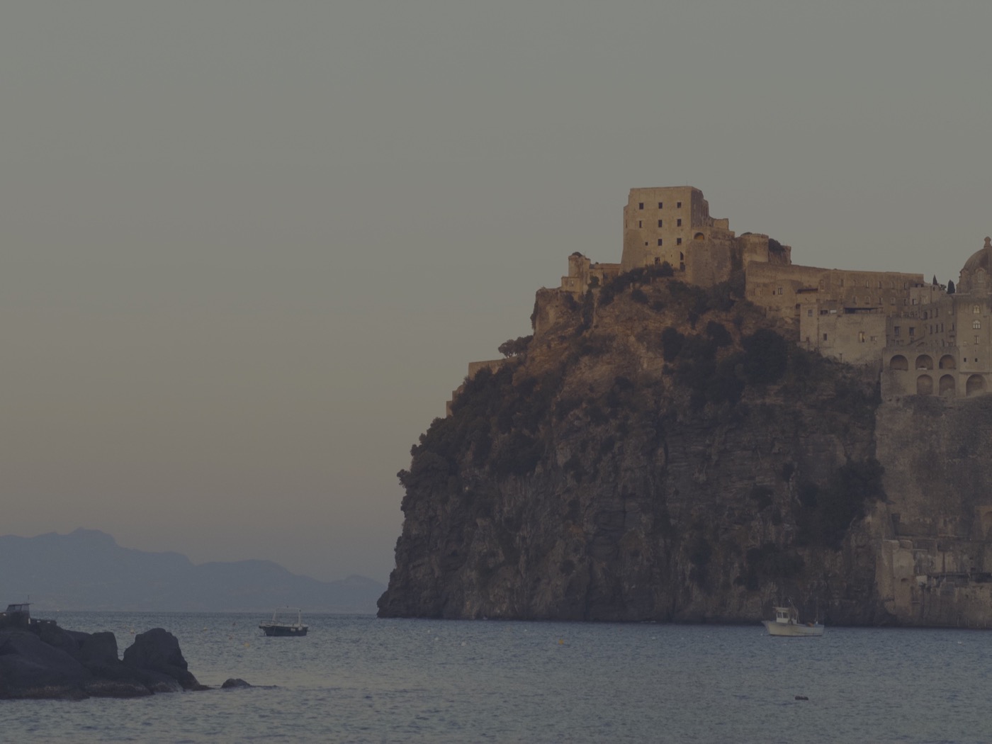 Castello Aragonese in silhouette as the sea turns gold