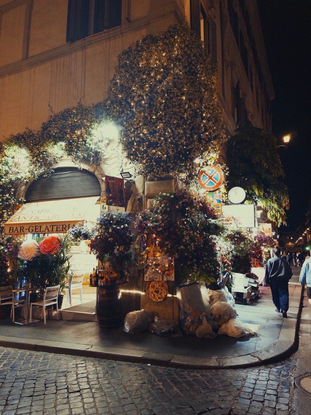 A café terrace covered in flowers at night